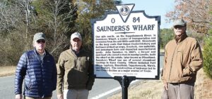 From left, Essex County Countryside Alliance President Peter Bance, Essex County Countryside Alliance Board member Sam Sturt, and Essex County North Election District Supervisor Sidney N. Johnson pose at historical markers recognizing the contributions of Saunders’s Wharf to the county’s history.