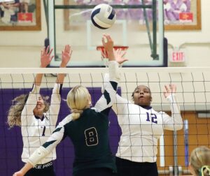 Essex’s Kaden Ramirez-Turner (7) and Aryeon Robinson defend against a spike by Northumberland’s Eva Williams.