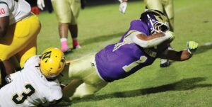 Essex quarterback Zay Bundy stretches out for a first down while being tackled by Northumberland’s Jemaris Barber.